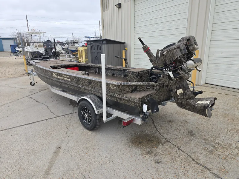 Slide: The Image of 2025 Pro-Drive 1854 boat on trailer, parked outside a garage. - 2