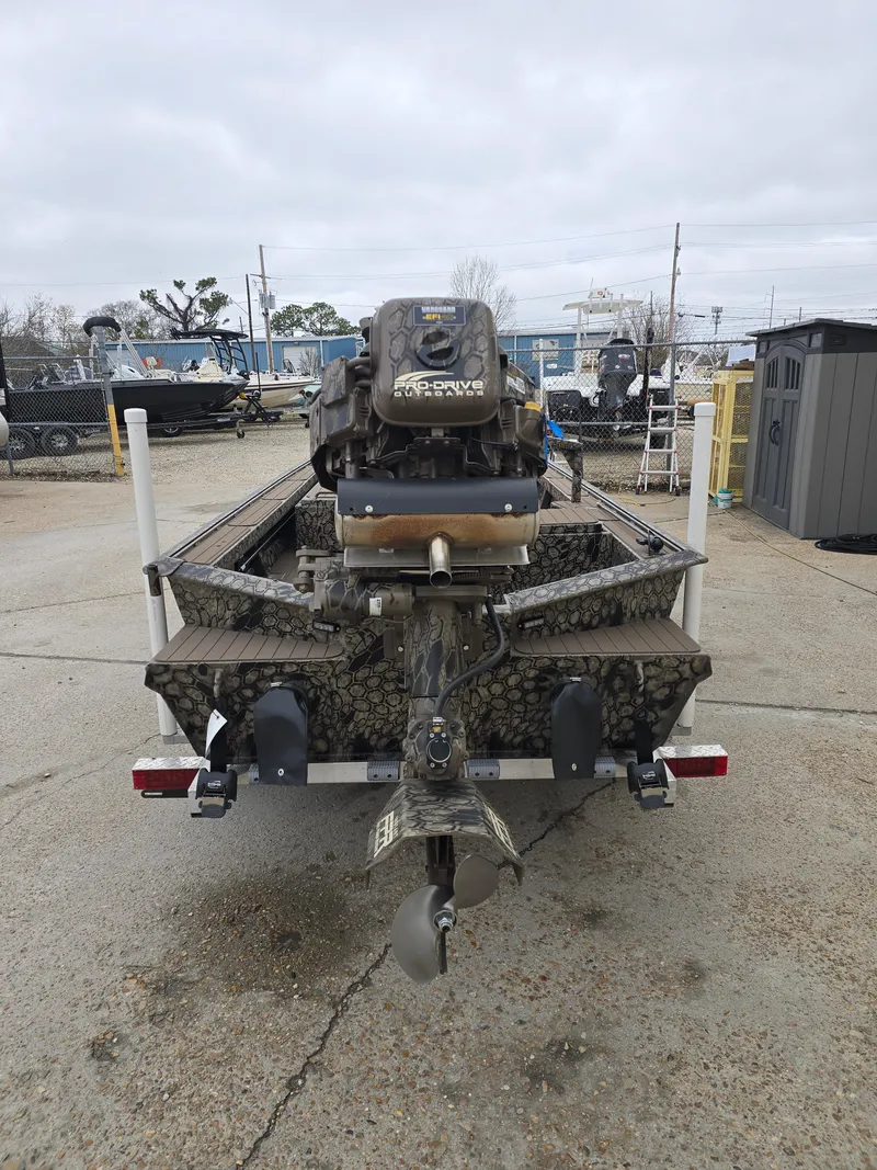 Slide: The Image of 2025 Pro-Drive 1854 boat with camo design and powerful outboard motor, parked outdoors. - 3