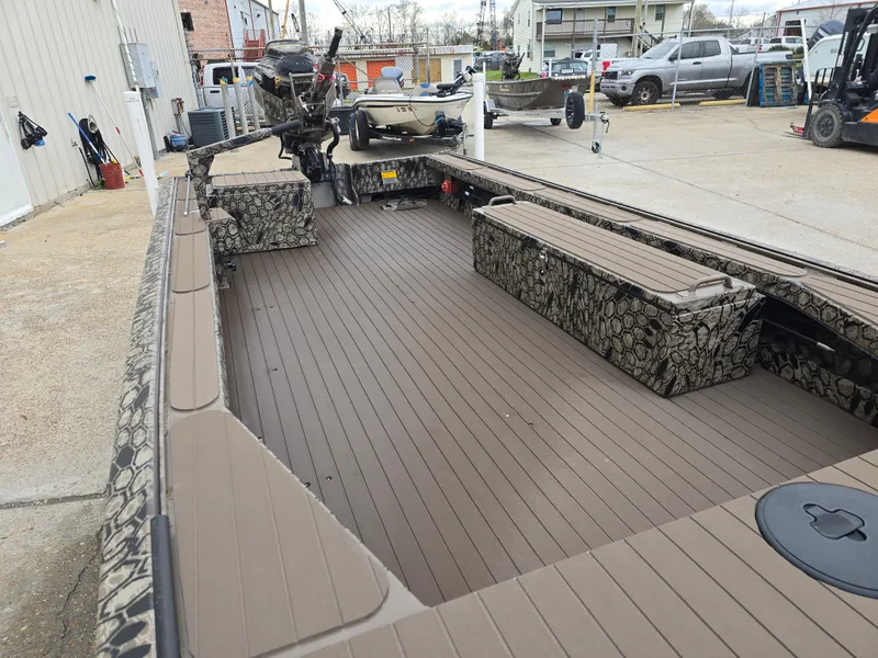 Slide: The Image of 2025 Pro-Drive 1854 boat with camouflage seating and spacious deck in a marina setting. - 7