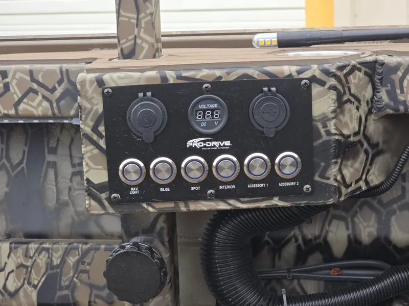 Slide: The Image of Control panel of 2025 Pro-Drive 1854 boat with camouflage design and voltage display. - 9