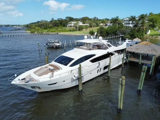 Slide: The Image of Astondoa 96 GLX 2009 yacht docked by a scenic waterfront with lush greenery. - 11