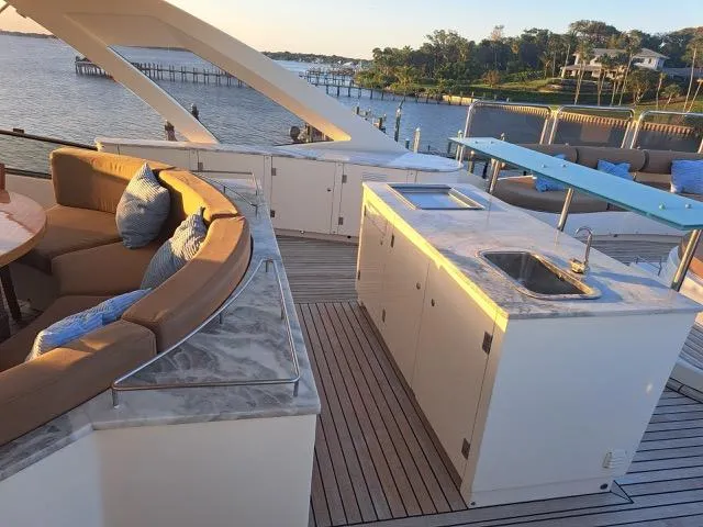 Slide: The Image of Luxurious 2009 Astondoa 95 GLX yacht deck with seating and kitchenette, overlooking serene waterfront. - 45