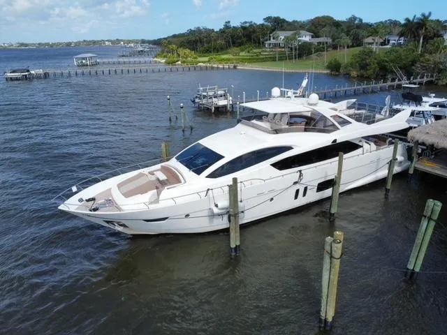 Slide: The Image of Astondoa 96 GLX 2009 yacht docked by a scenic waterfront with lush greenery. - 6