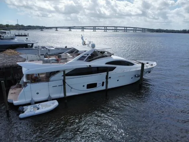 Slide: The Image of Astondoa 96 GLX yacht from 2009 docked by the water with a bridge in the background. - 9