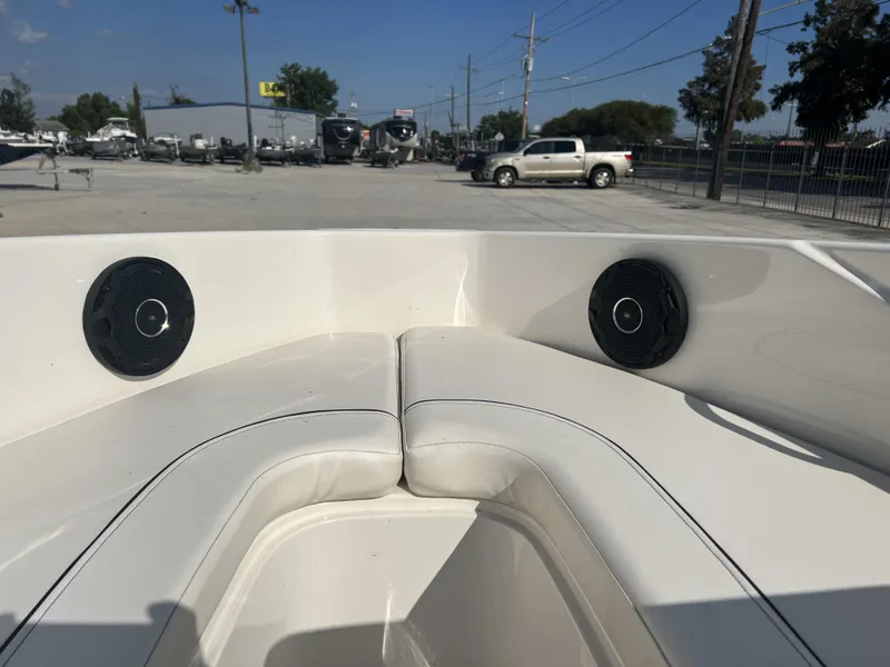 Slide: The Image of 2016 Bayliner 175 boat interior with speakers and seating in a parking lot. - 14