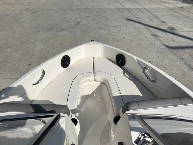 Slide: The Image of 2016 Bayliner 175 boat interior with seating and speakers, parked on concrete. - 16