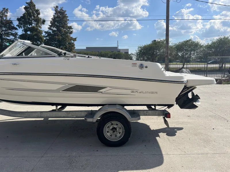 Slide: The Image of 2016 Bayliner 175 boat on trailer, parked outdoors under a clear sky. - 3