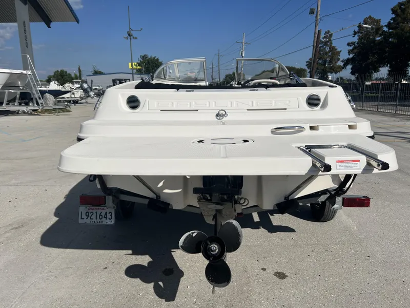 Slide: The Image of 2016 Bayliner 175 boat rear view, parked on a trailer in a marina. - 6