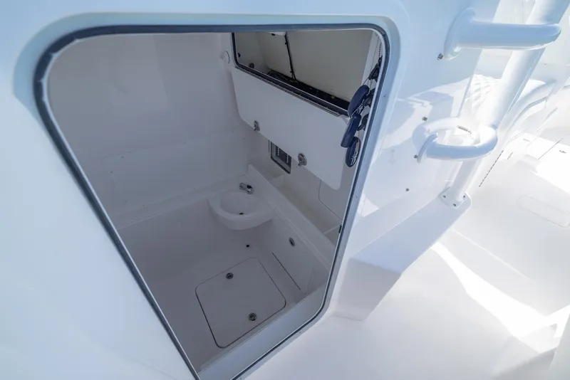 Slide: The Image of 2025 Invincible 36 Open Fisherman boat interior, featuring a compact marine toilet. - 24