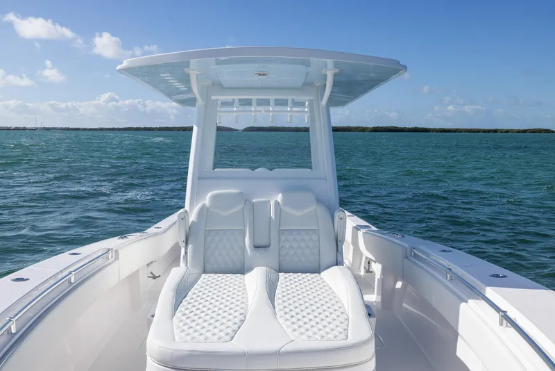 Slide: The Image of Invincible 36 Open Fisherman 2025 boat on open water, featuring sleek white seating. - 8