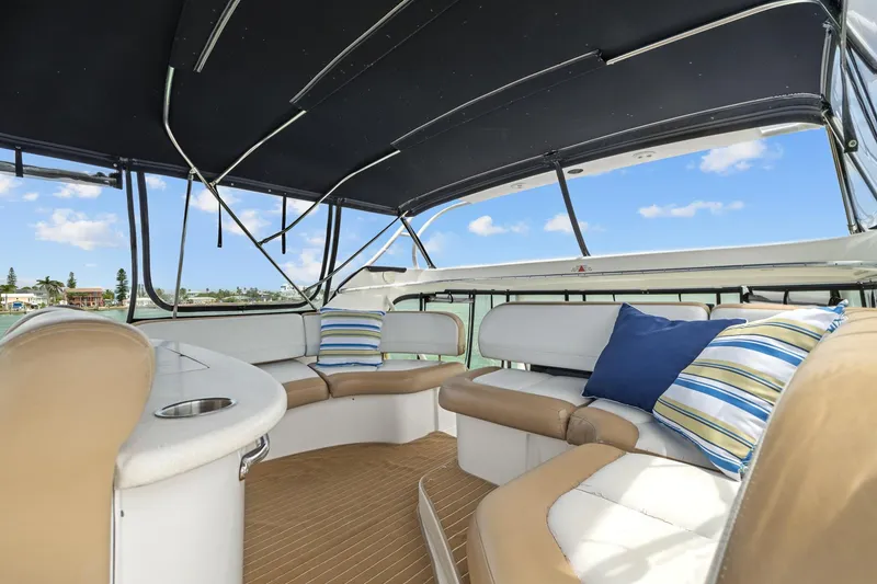 Slide: The Image of 2002 Silverton 43 Motor Yacht interior with cushioned seating and striped pillows under a canopy. - 13