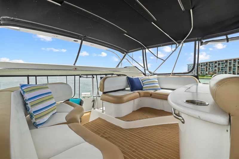 Slide: The Image of 2002 Silverton 43 Motor Yacht interior with cushioned seating and scenic water view. - 14