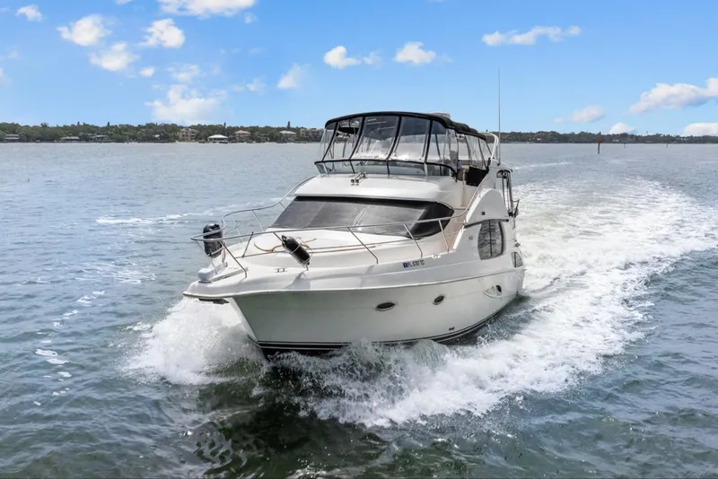 Slide: The Image of 2002 Silverton 43 Motor Yacht cruising on open water under a clear blue sky. - 2