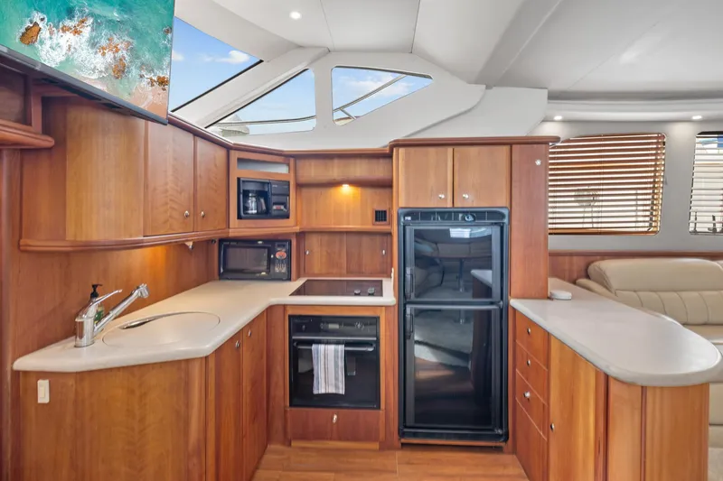 Slide: The Image of Luxurious kitchen interior of 2002 Silverton 43 Motor Yacht with modern appliances and wood cabinetry. - 21
