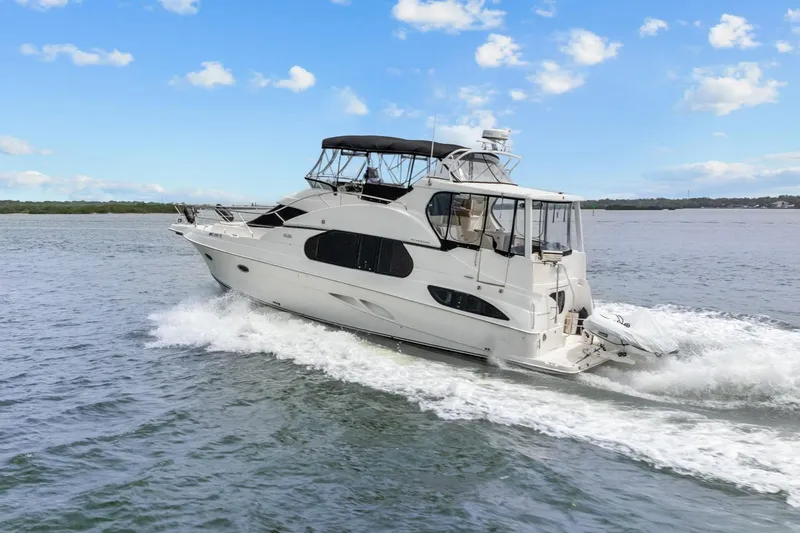 Slide: The Image of 2002 Silverton 43 Motor Yacht cruising on open water under a clear blue sky. - 3