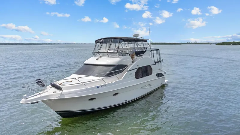 Slide: The Image of 2002 Silverton 43 Motor Yacht cruising on calm waters under a clear blue sky. - 6
