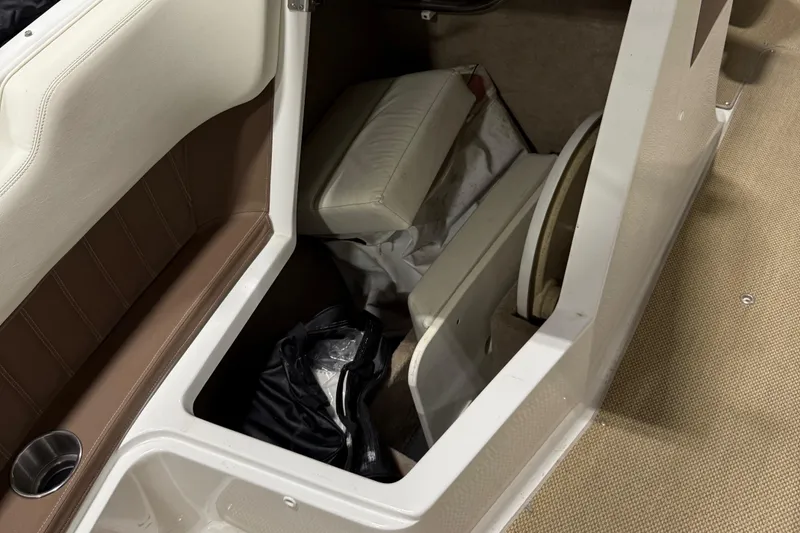 Slide: The Image of 2012 Cobalt 262 Bowrider interior storage compartment with seat cushions and accessories. - 5