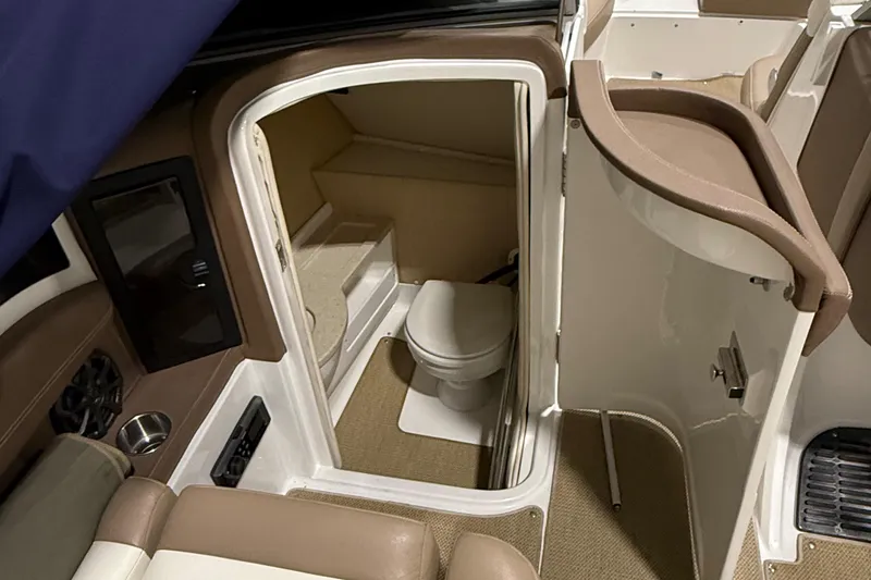 Slide: The Image of Interior of 2012 Cobalt 262 Bowrider boat featuring a compact bathroom. - 8