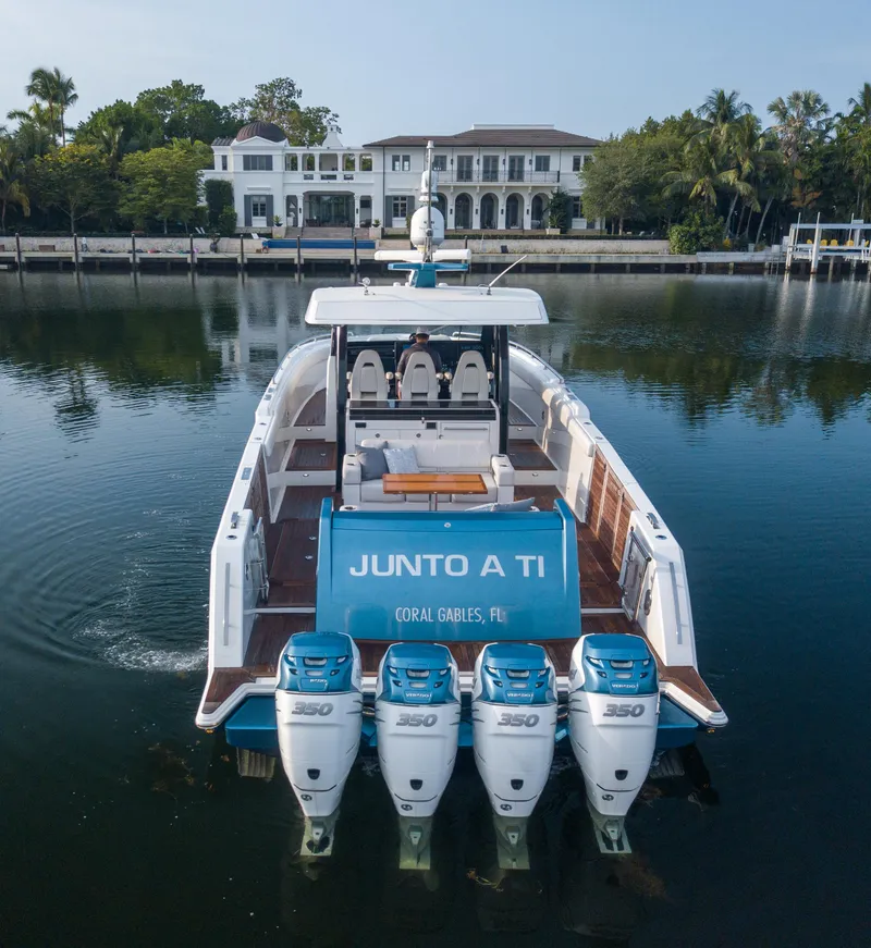 Slide: The Image of 2020 Ocean Alexander 45 Divergence Sport yacht with four engines, docked near a luxury waterfront home. - 2