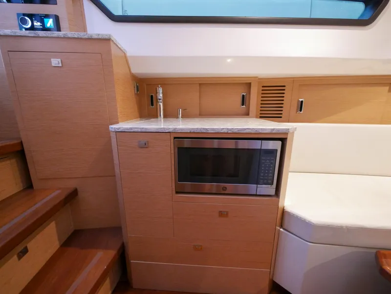 Slide: The Image of 2020 Ocean Alexander 45 Divergence Sport interior with microwave and wooden cabinetry. - 31