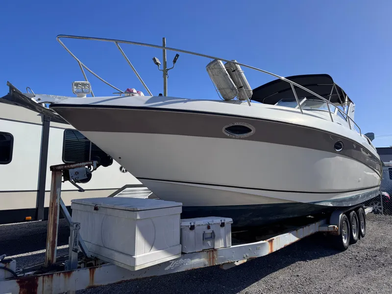 The Image of 1999 Regal 322 Commodore boat on trailer under clear blue sky. - 0
