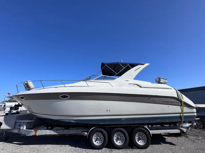 Slide: The Image of 1999 Regal 322 Commodore boat on trailer under clear blue sky. - 1