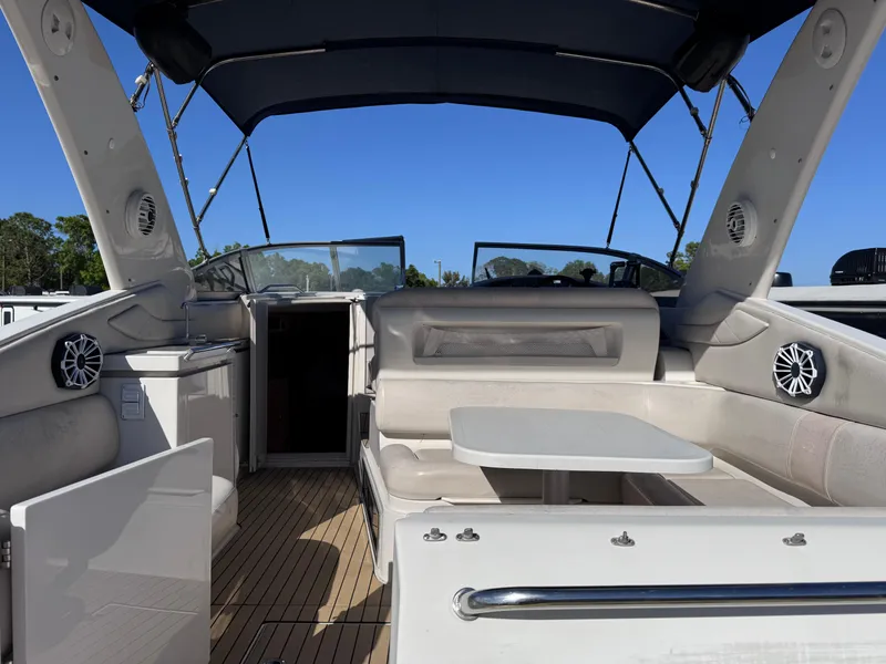 Slide: The Image of 1999 Regal 322 Commodore boat interior with seating and table under canopy. - 18