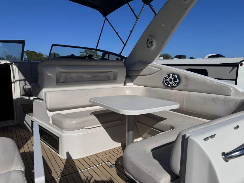Slide: The Image of 1999 Regal 322 Commodore boat interior with seating and table under blue sky. - 19
