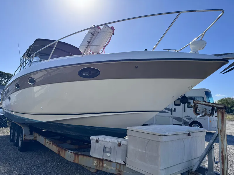 Slide: The Image of 1999 Regal 322 Commodore boat on trailer under clear blue sky. - 2