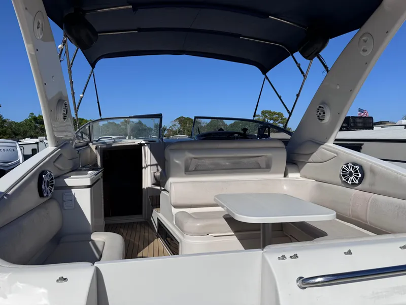 Slide: The Image of 1999 Regal 322 Commodore boat interior with seating and table under canopy. - 23