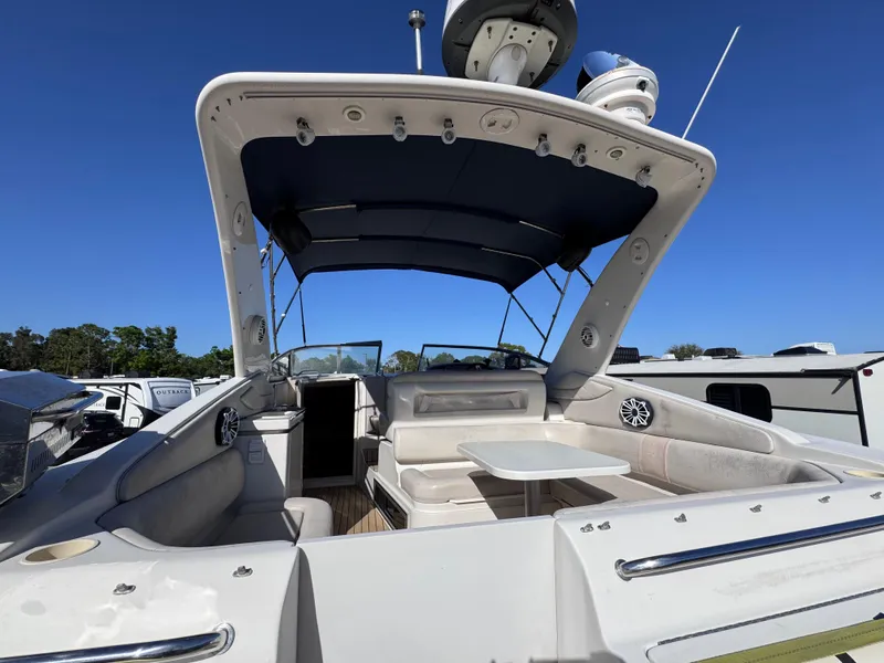 Slide: The Image of 1999 Regal 322 Commodore boat with spacious seating and canopy, docked under clear blue sky. - 24