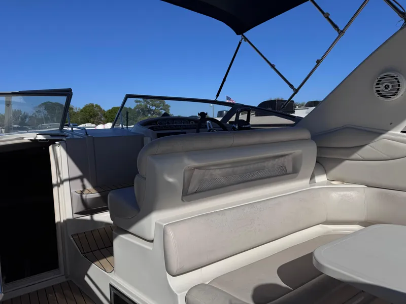 Slide: The Image of 1999 Regal 322 Commodore boat interior with seating and steering area under a clear blue sky. - 26