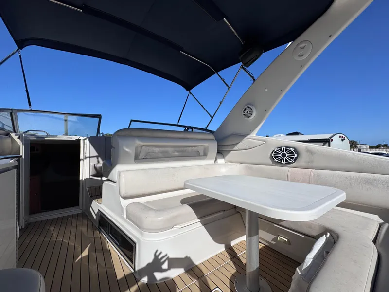 Slide: The Image of 1999 Regal 322 Commodore boat interior with seating and table under a canopy. - 34