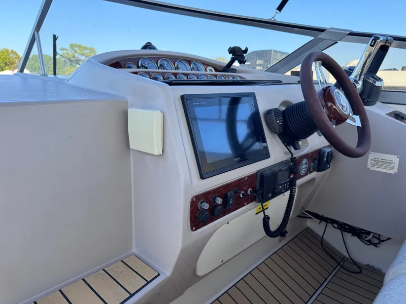 Slide: The Image of 1999 Regal 322 Commodore boat dashboard with steering wheel and navigation controls. - 36