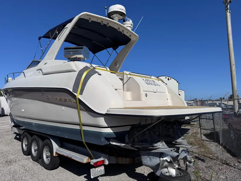Slide: The Image of 1999 Regal 322 Commodore boat on trailer, outdoor storage, clear sky background. - 5