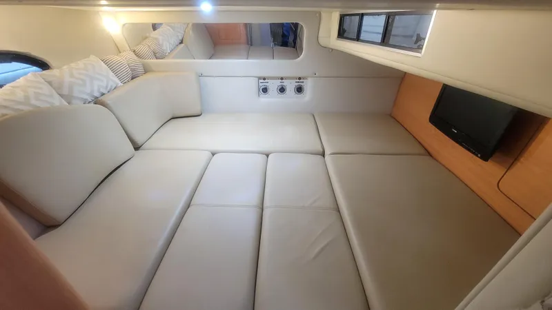 Slide: The Image of 1999 Regal 322 Commodore interior cabin with beige seating and small TV. - 79