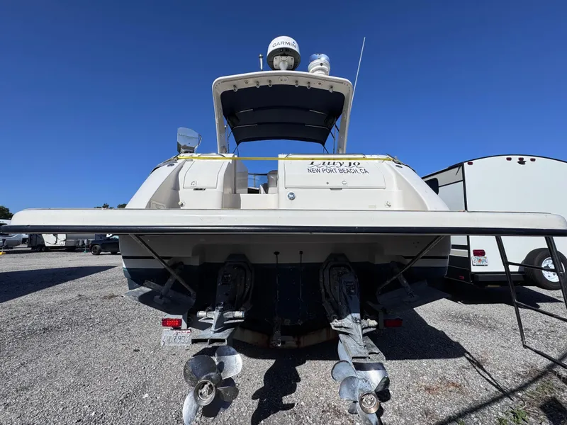 Slide: The Image of 1999 Regal 322 Commodore boat, rear view, parked on gravel, clear blue sky. - 8
