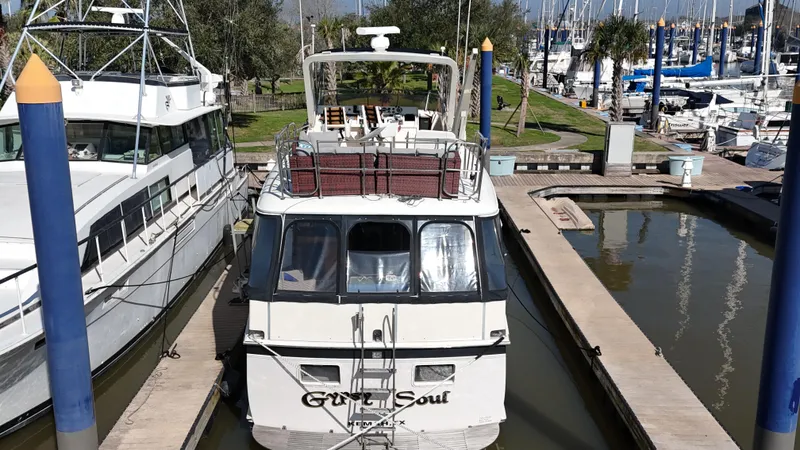 Slide: The Image of 1978 Hatteras 53 Motor Yacht docked in marina, surrounded by other boats. - 10