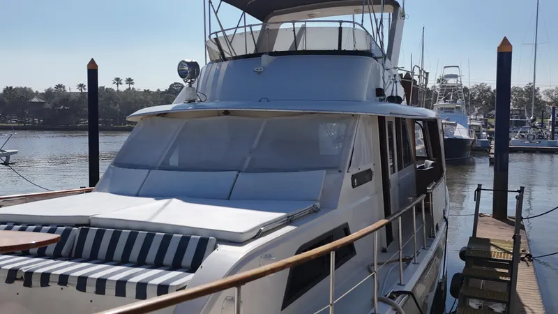 Slide: The Image of 1978 Hatteras 53 Motor Yacht docked at marina, featuring sleek design and spacious deck. - 11