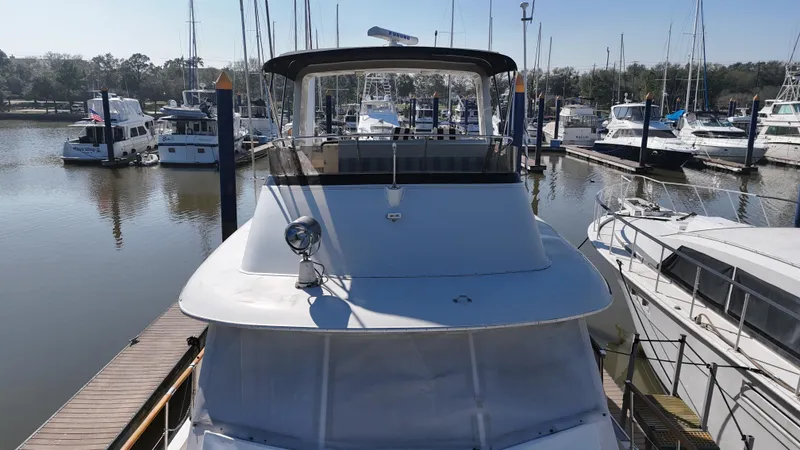 Slide: The Image of 1978 Hatteras 53 Motor Yacht docked in a marina, surrounded by other boats. - 13