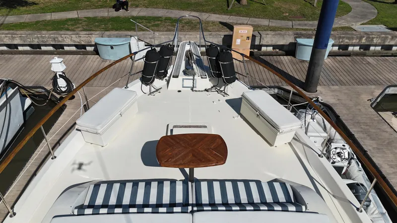 Slide: The Image of 1978 Hatteras 53 Motor Yacht deck with seating and table at marina. - 14