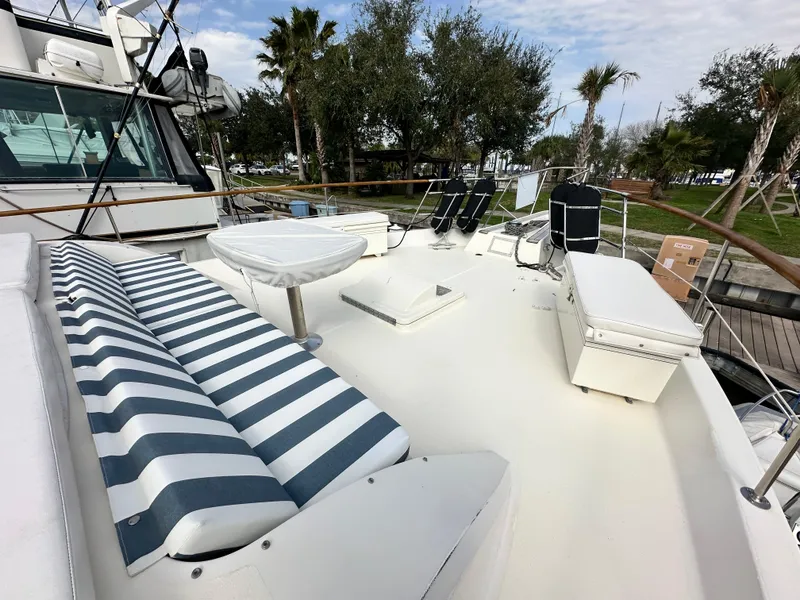 Slide: The Image of 1978 Hatteras 53 Motor Yacht deck with striped seating and outdoor furniture. - 18