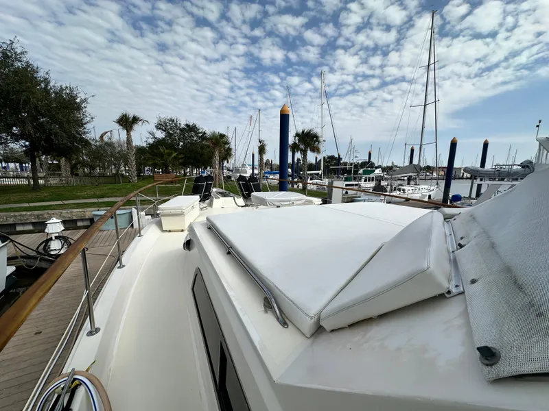Slide: The Image of 1978 Hatteras 53 Motor Yacht docked at marina under partly cloudy sky. - 19