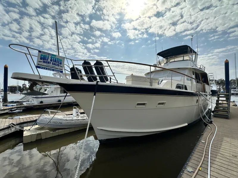 Slide: The Image of 1978 Hatteras 53 Motor Yacht docked under a partly cloudy sky. - 2
