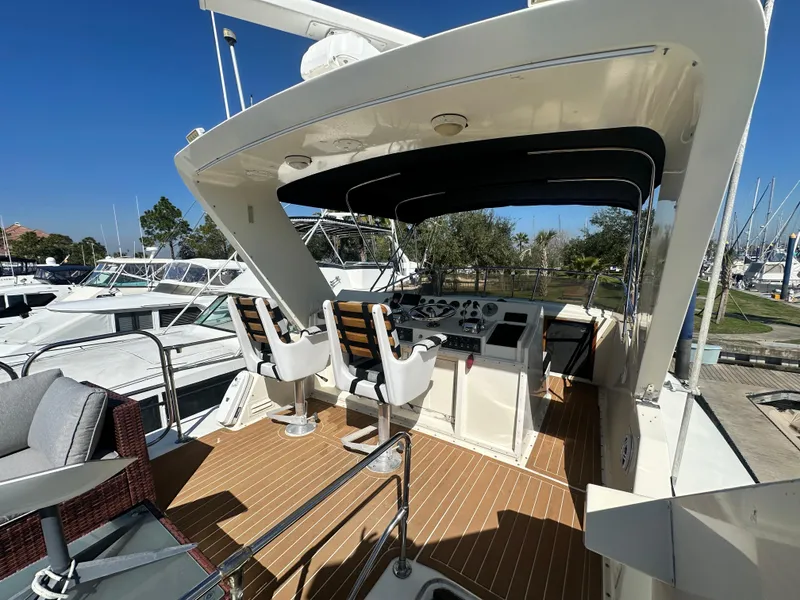Slide: The Image of 1978 Hatteras 53 Motor Yacht helm with seating, docked under clear blue sky. - 20