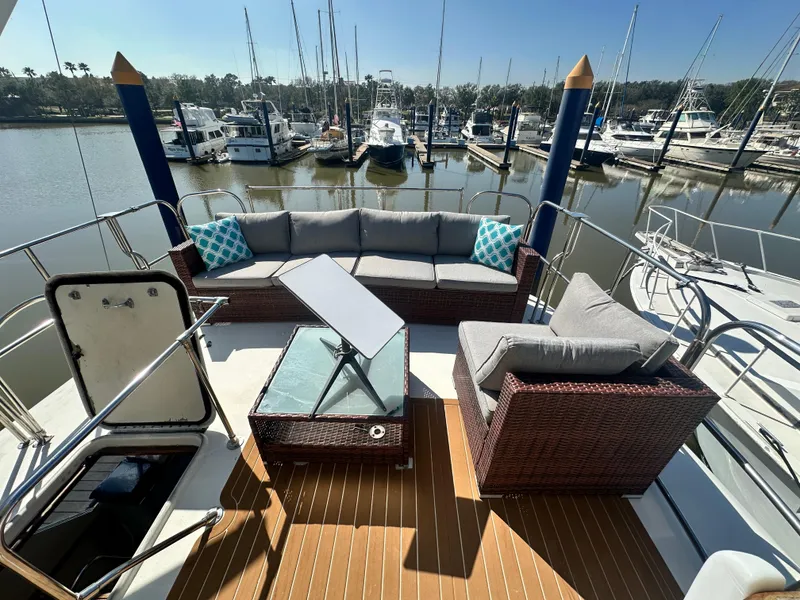 Slide: The Image of 1978 Hatteras 53 Motor Yacht with outdoor seating, docked at a marina. - 21