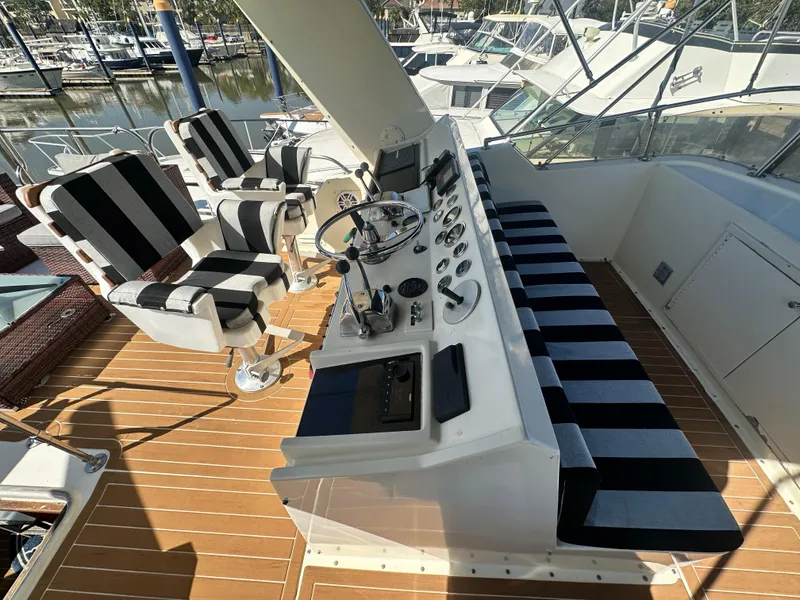 Slide: The Image of 1978 Hatteras 53 Motor Yacht helm with striped seating and wooden deck. - 29