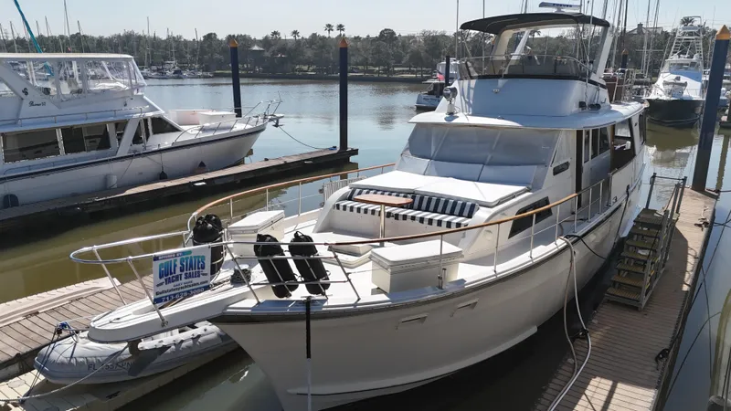 Slide: The Image of 1978 Hatteras 53 Motor Yacht docked at marina, for sale sign visible. - 3