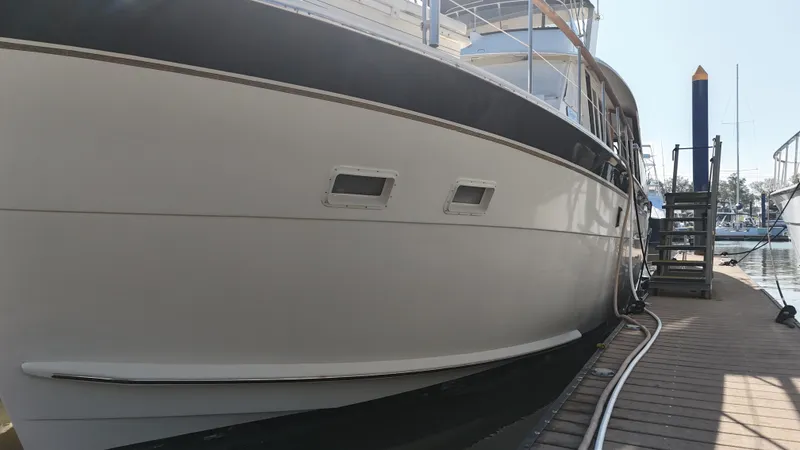 Slide: The Image of 1978 Hatteras 53 Motor Yacht docked, showcasing sleek hull design and classic elegance. - 4