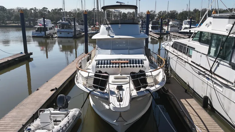 Slide: The Image of 1978 Hatteras 53 Motor Yacht docked at marina, surrounded by other boats. - 6